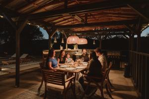 a group of people sitting around a table on a patio at Boho chic oasis by Casa Oso with pool, spa and views in Ahwahnee