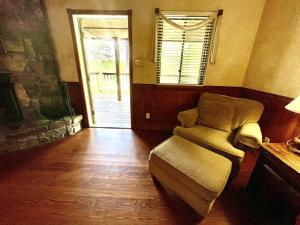 ein Wohnzimmer mit einem Stuhl und einem Fenster in der Unterkunft C9, Two bedroom, two bath, log-sided, lake view cottage with hot tub cottage in Mount Ida + 24 Fotos