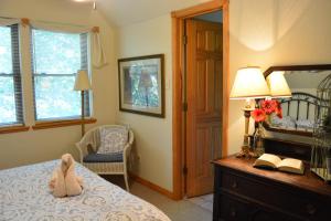um quarto com um urso de peluche sentado numa cama em C10, Two bedroom, two bath log-sided, lake view, luxury Harbor North cottage with hot tub cottage em Mount Ida