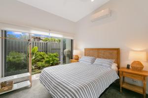 une chambre avec un lit et une grande fenêtre dans l'établissement Sunfish Special - Beachside Townhouse by uHoliday, à Kingscliff