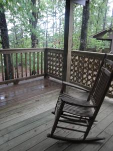 einem Schaukelstuhl auf einer Holzterrasse in der Unterkunft Mountain Harbor Forest View Lodge cottage in Mount Ida