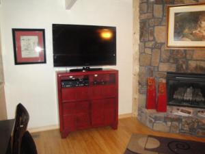 ein Wohnzimmer mit einem TV auf einer roten Kommode in der Unterkunft Mountain Harbor Forest View Lodge cottage in Mount Ida