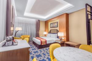 una camera d'albergo con letto, tavoli e sedie di MPalace Hotel KL a Kuala Lumpur