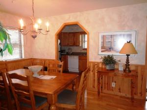 a dining room with a table and a kitchen at Luxury, loft, log-sided two bedroom Harbor North cottage cottage in Mount Ida