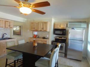 a kitchen with a table and a refrigerator at Poolside Queen Cabana with two queen beds, full kitchen and pool access overlooking Lake Ouachita, Hotel Room in Mount Ida