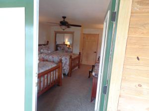 1 dormitorio con 2 camas y ventilador de techo en C23, Two bedroom, two bath log-sided, luxury Harbor North cottage with hot tub cottage, en Mount Ida