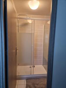 a shower with a glass door in a bathroom at Studio Cosy et fonctionnel drancy CDG in Drancy