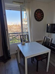 a white table and chairs in a room with a window at Studio Cosy et fonctionnel drancy CDG in Drancy