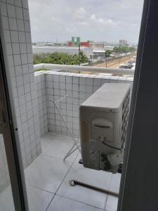 a tiled bathroom with a computer monitor and a window at Ap próx shopping aeroporto in Recife