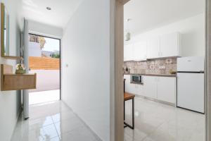 a kitchen with white cabinets and a table at Άνετο διαμέρισμα με κήπο in Rhodes Town