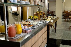 una linea a buffet con un sacco di cibo e bevande di GH Hotel Express a Juiz de Fora