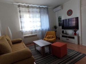 uma sala de estar com um sofá e uma televisão em Folka cozy apartment em Zagreb