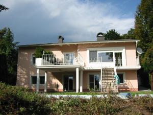 a large pink house with a balcony at Holiday Apartment Krumpendorf in Krumpendorf am Wörthersee