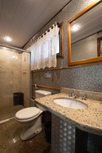a bathroom with a toilet and a sink at Hotel Green Hill in Juiz de Fora