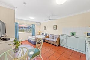 Koala Court Holiday Apartments في كيرنز: غرفة معيشة مع أريكة وطاولة