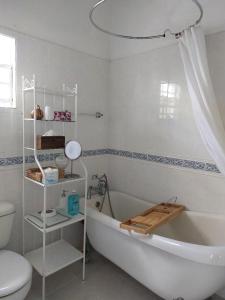 La salle de bains blanche est pourvue d'une baignoire et de toilettes. dans l'établissement Selen's Apartment in Ti Rocher Micoud Saint Lucia, à Micoud