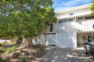 a house with a tree in front of it at Pandanus Pocket 3BR Beachside Condo by uHoliday in Casuarina