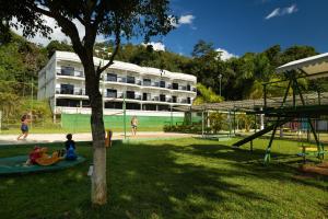een park met een speeltuin met een gebouw op de achtergrond bij Hotel Green Hill in Juiz de Fora