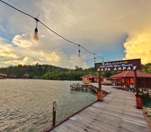 Coriana Dive Resort في Waisai: مرسى على البحيرة مع وضع علامة عليه