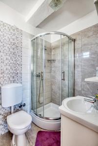 a bathroom with a shower and a toilet and a sink at Apartments by the sea Grebastica, Sibenik - 11463 in Grebaštica