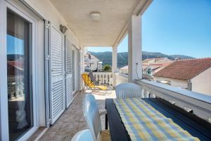 a balcony with a table and chairs on a patio at Apartments by the sea Grebastica, Sibenik - 11463 in Grebaštica