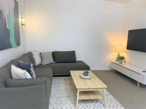 a living room with a couch and a coffee table at Pandanus Pocket 3BR Beachside Condo by uHoliday in Casuarina