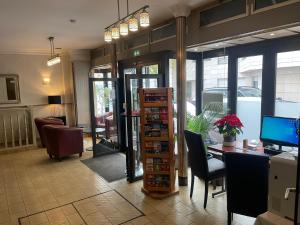 eine Lobby mit einem Schreibtisch und einem Tisch mit Stühlen in der Unterkunft Crystal Hotel in Levallois-Perret