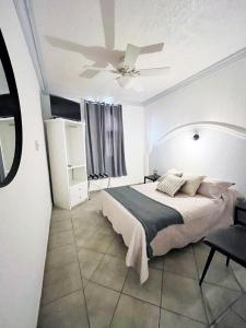 a bedroom with a bed and a ceiling fan at Hotel Plaza San Juan in San Juan de los Lagos