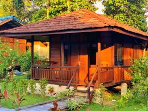 una piccola casa in legno con un ampio ponte di Coriana Dive Resort a Waisai