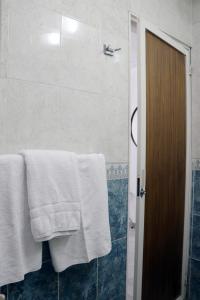 a bathroom with white towels and a shower at Hotel Plaza San Juan in San Juan de los Lagos