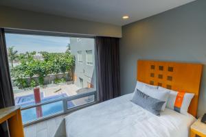 a bedroom with a bed and a large window at Real Inn Torreon in Torreón