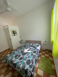 1 dormitorio con cama y alfombra verde en Charmante maison, en Deshaies