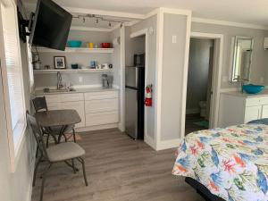 a bedroom with a bed and a table and a kitchen at Angler's Inn in Matlacha