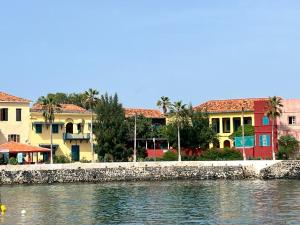 a group of buildings next to a body of water at Principauté in Gorée