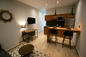 a kitchen with a counter and stools in a room at Punto Lofts Periférico Sur in Mexico City
