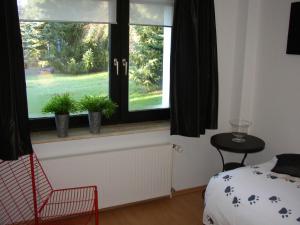 ヴィンターベルクにあるLandhaus zur Lindeのベッドルーム1室(窓、ベッド1台、椅子付)