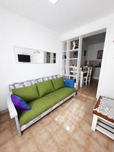 ein Wohnzimmer mit einer grünen Couch in einem Zimmer in der Unterkunft Soñar en la Patagonia in Trelew