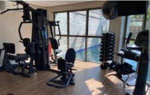 a gym with exercise equipment in a room with a window at Samba convention suites in Rio de Janeiro