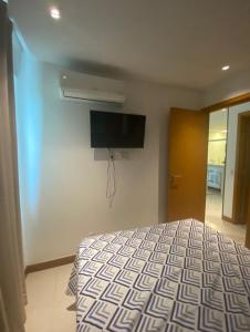 um quarto com uma cama e uma televisão na parede em Samba convention suites no Rio de Janeiro