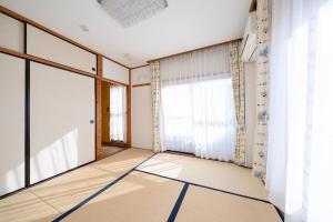 鳥取市にあるWhole house rental 一棟貸切宿 "Your Home Tottori" 市内中心地近くの素敵な一軒家の大きな窓が付いた空の部屋