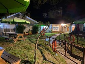 a group of picnic tables and umbrellas at night at Hostel del Puerto in Punta del Este