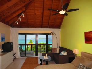a living room with a couch and a ceiling fan at Luxury Beachfront Duplex Villa on Sapphire Beach I in East End