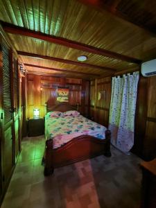 a bedroom with a bed in a wooden room at Cabaña 12 La Bendición De Dios in Santa Marta