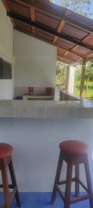 a kitchen with two stools in front of a counter at Casa Ceiba Mar cerca a Volcán in Arboletes