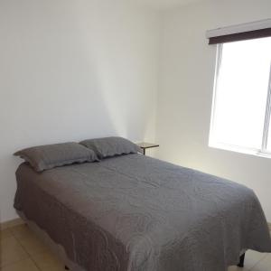 a bed in a white bedroom with a window at Casa Libertad in Guanajuato