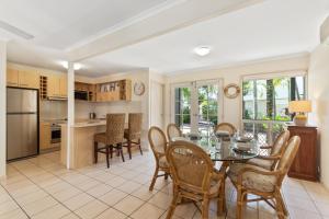 una cucina e una sala da pranzo con tavolo e sedie di Coco Bay Resort a Noosaville