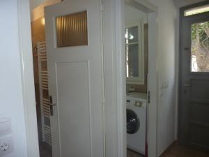 uma porta para uma lavandaria com uma máquina de lavar roupa em A Painter's House in Plaka em Atenas