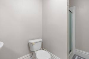 een witte badkamer met een toilet in een kamer bij The Heights Hideaway a Stylish & Spacious Retreat in Tower Grove