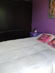 Una cama blanca con dos almohadas encima. en Como en casa en Gualeguaychú