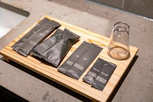 a wooden cutting board with a glass bottle and napkins at Hotel mio in Shimabara
